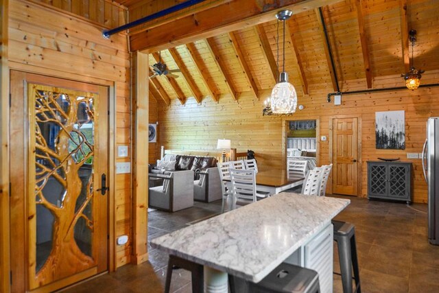 2837 Cedar Falls Way, Sevierville, TN 37862 - kitchen featuring freestanding refrigerator, a breakfast bar area, wood walls, wooden ceiling, and vaulted ceiling with beams