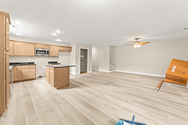 1039 Cedar Ln, Sevierville, TN 37862 - kitchen featuring stainless steel microwave, dark countertops, light wood-type flooring, recessed lighting, and a center island