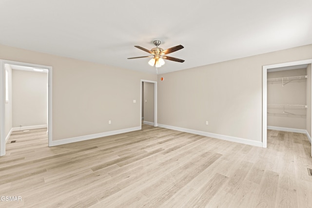 1039 Cedar Ln, Sevierville, TN 37862 - unfurnished bedroom with light wood finished floors, a walk in closet, a closet, and a ceiling fan