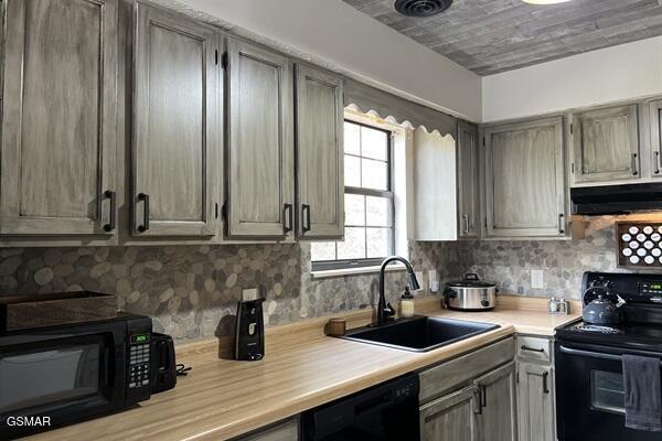 kitchen featuring black appliances, sink, exhaust hood, and tasteful backsplash