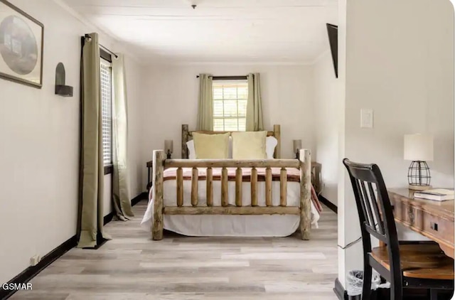 bedroom with crown molding and light wood-type flooring