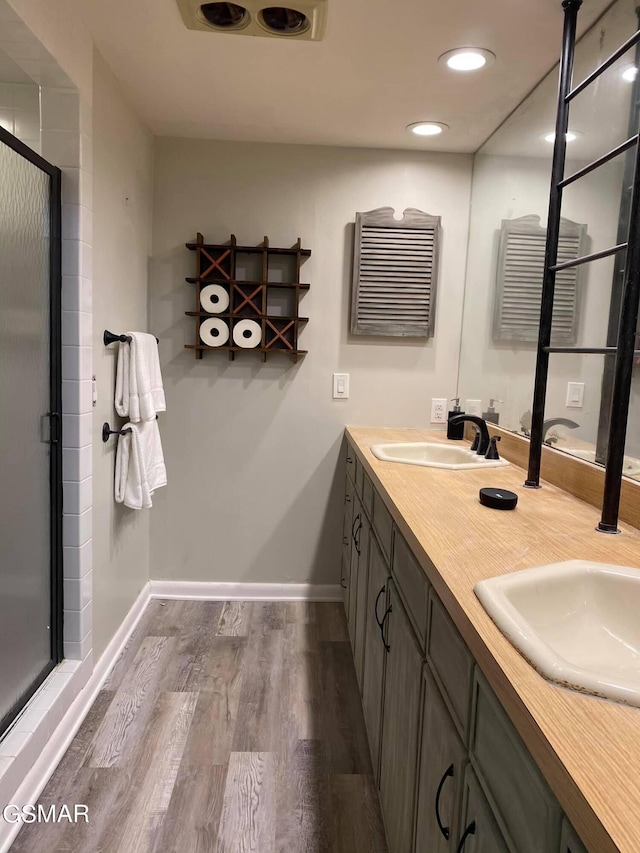 bathroom featuring hardwood / wood-style floors, vanity, and a shower with door