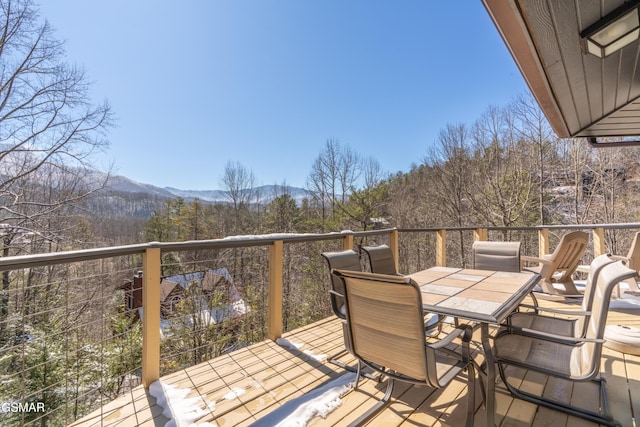 wooden deck featuring a mountain view and outdoor dining area