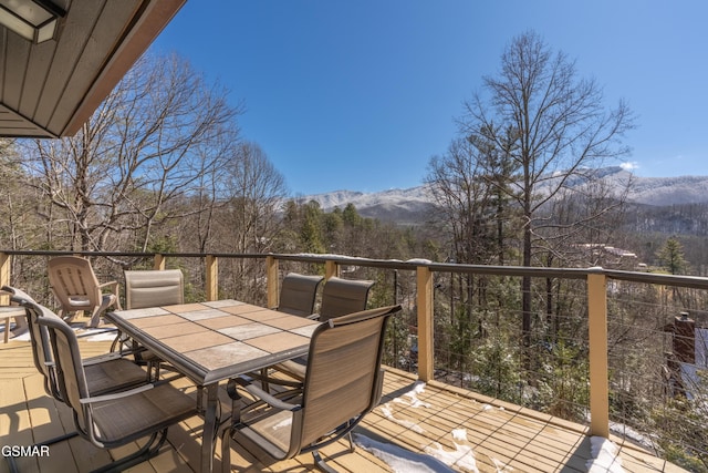 deck featuring a mountain view and outdoor dining area