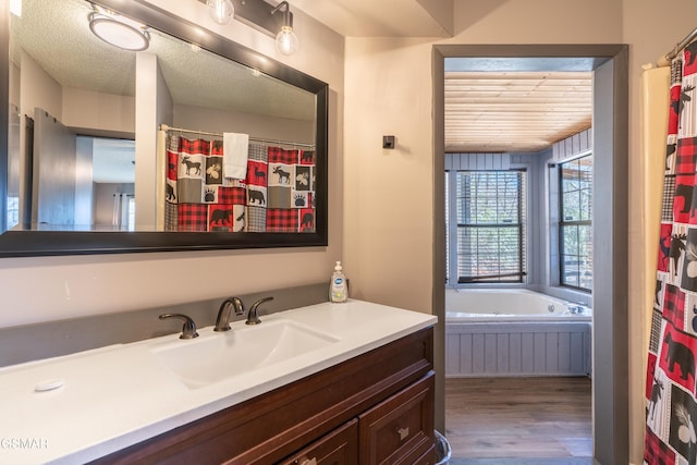 3709 Eagle Ln, Gatlinburg, TN 37738 - bathroom featuring a textured ceiling, wood finished floors, vanity, and a bathtub