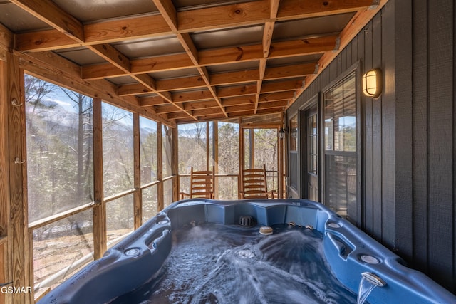 unfurnished sunroom featuring coffered ceiling and a hot tub