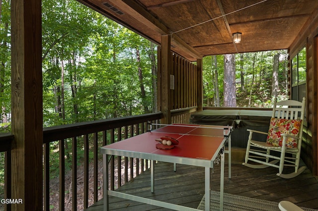 wooden terrace with visible vents and a hot tub