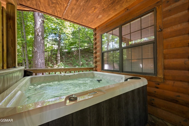 unfurnished sunroom with wood ceiling and a jacuzzi