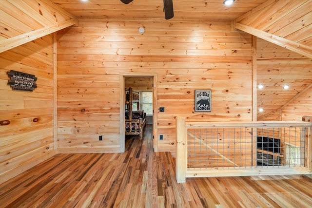 corridor featuring wood-type flooring, lofted ceiling, wood ceiling, and wood walls