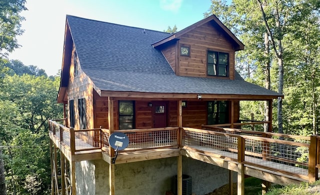 log home featuring cooling unit and a wooden deck