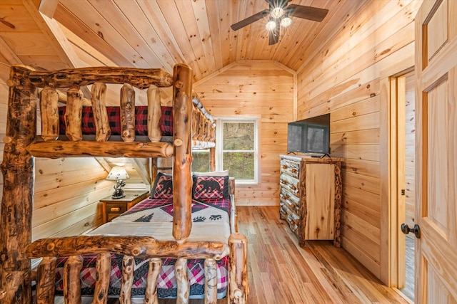 bedroom featuring wood ceiling, vaulted ceiling, light hardwood / wood-style floors, and wooden walls