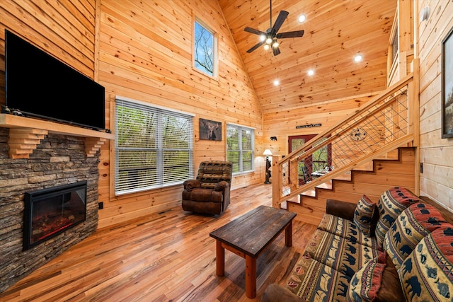 living room with a fireplace, a healthy amount of sunlight, and wooden walls