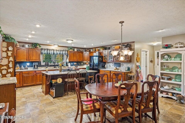 dining area featuring a chandelier, a textured ceiling, and sink