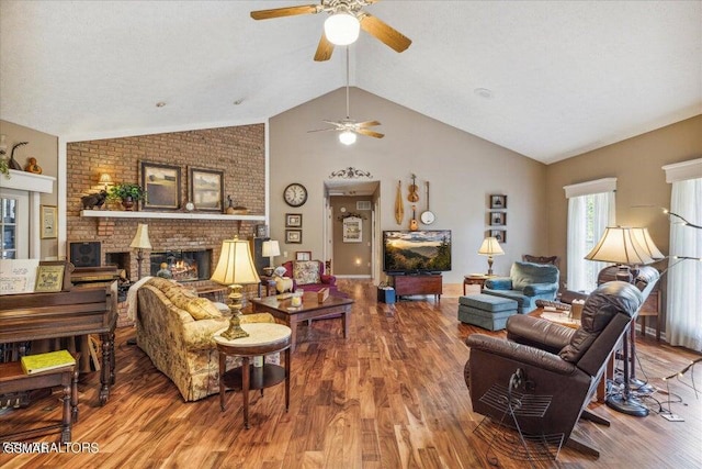 living room with ceiling fan, a fireplace, lofted ceiling, and hardwood / wood-style flooring