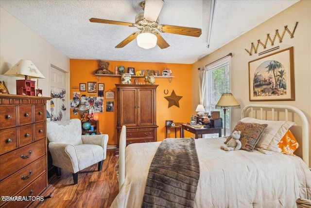 bedroom with ceiling fan, dark hardwood / wood-style flooring, and a textured ceiling