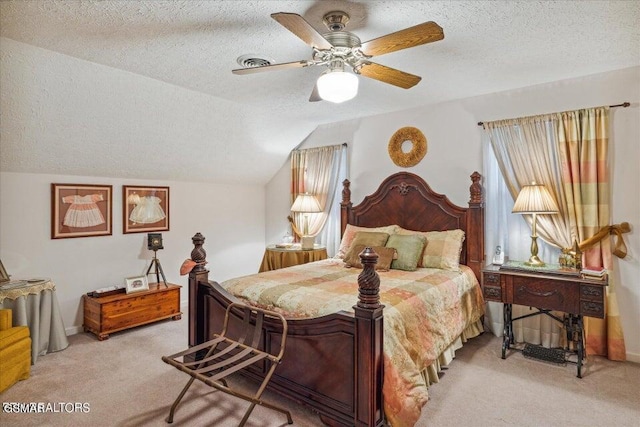 bedroom with a textured ceiling, ceiling fan, light carpet, and vaulted ceiling