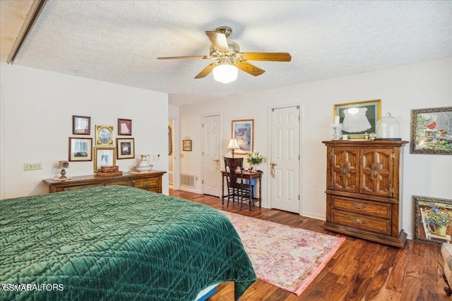 bedroom featuring ceiling fan, hardwood / wood-style floors, and a textured ceiling