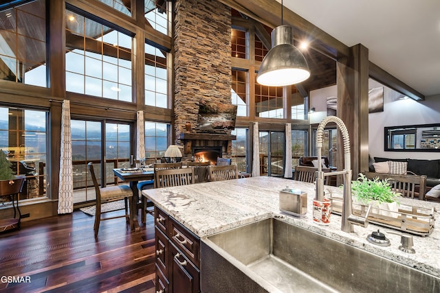 710 Wiley Oakley Dr, Gatlinburg, TN 37738 - kitchen with a sink, open floor plan, dark wood finished floors, a stone fireplace, and light stone counters