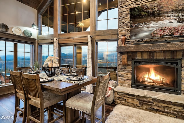 710 Wiley Oakley Dr, Gatlinburg, TN 37738 - dining room with wood finished floors, a towering ceiling, a stone fireplace, and healthy amount of natural light