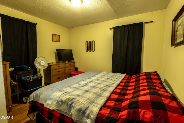 bedroom with hardwood / wood-style flooring and a textured ceiling