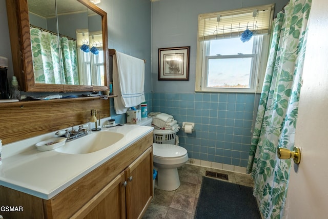 bathroom with a shower with curtain, vanity, tile walls, and toilet