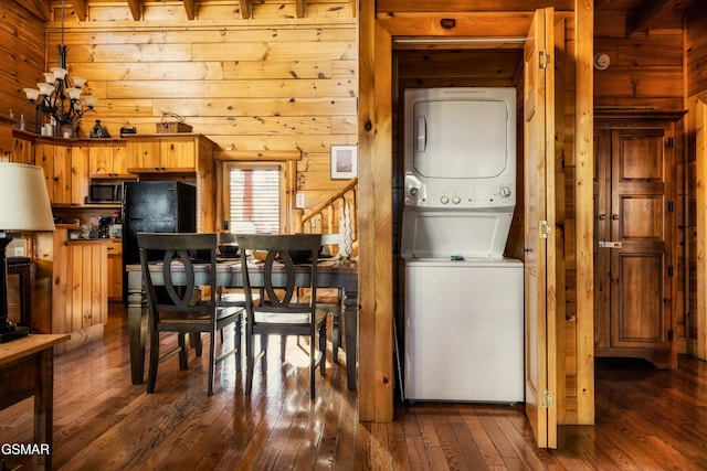 2017 Smoky Cove Rd, Sevierville, TN 37876 - dining area with stacked washer / drying machine, wood walls, dark wood finished floors, and a chandelier
