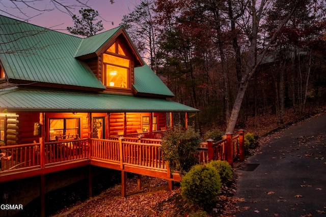2017 Smoky Cove Rd, Sevierville, TN 37876 - back of house at dusk with metal roof, log siding, and a porch