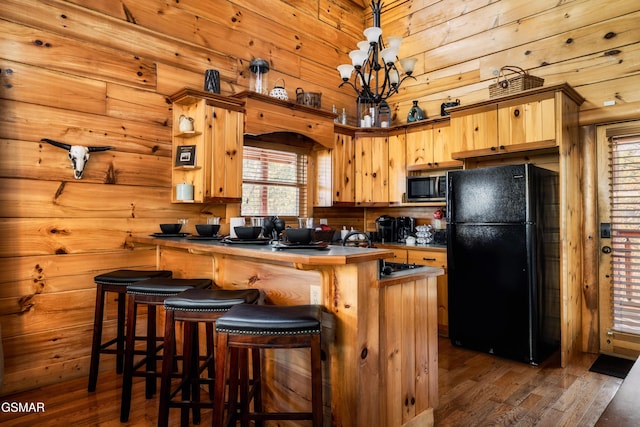 2017 Smoky Cove Rd, Sevierville, TN 37876 - kitchen featuring freestanding refrigerator, stainless steel microwave, a peninsula, dark wood-style floors, and wood walls