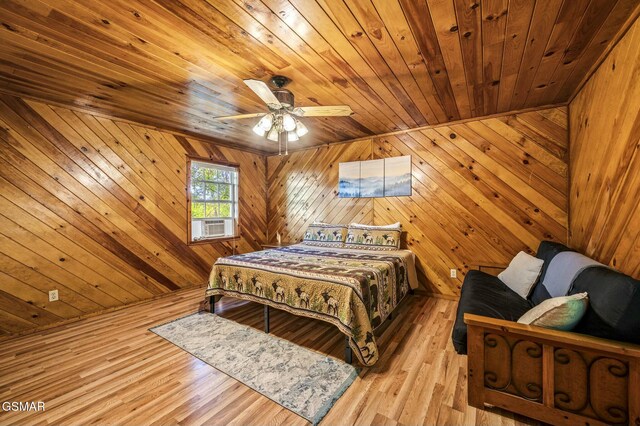 bedroom featuring cooling unit, wooden walls, ceiling fan, wooden ceiling, and light hardwood / wood-style floors