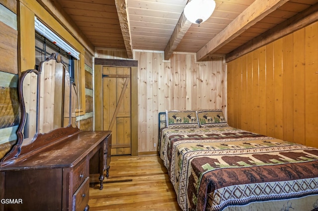 bedroom featuring wooden walls, beamed ceiling, wooden ceiling, and light wood-type flooring