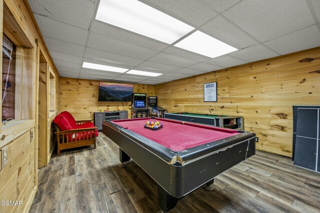 game room with wood walls, a drop ceiling, and pool table