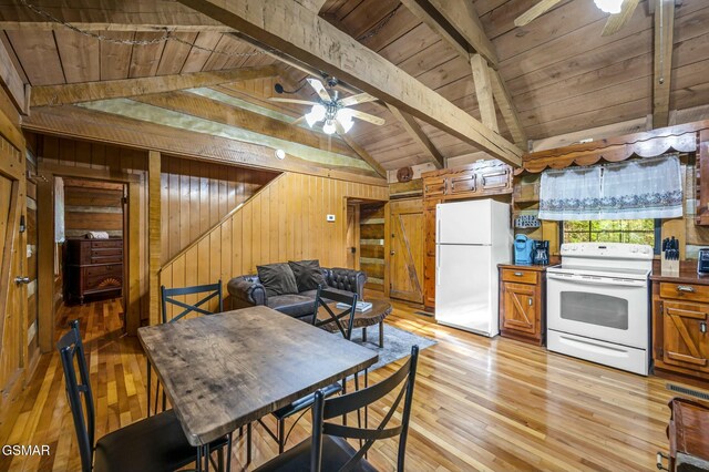 dining space with ceiling fan, lofted ceiling with beams, wood ceiling, and wood walls