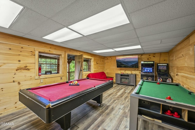 rec room featuring wooden walls, a drop ceiling, hardwood / wood-style flooring, and billiards