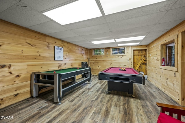 playroom featuring a drop ceiling, wood walls, billiards, dark hardwood / wood-style floors, and a barn door