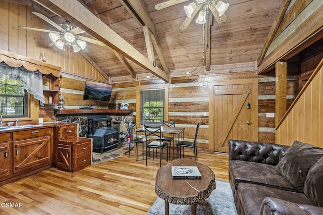 living room with a healthy amount of sunlight, wood walls, wooden ceiling, and light wood-type flooring