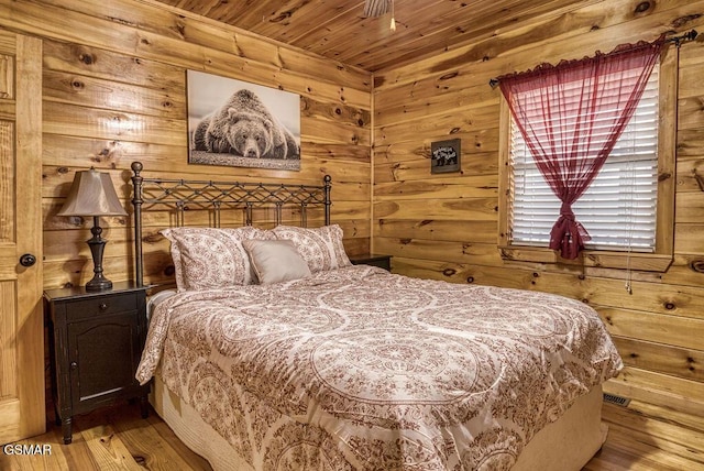 bedroom featuring hardwood / wood-style flooring, wooden walls, and wooden ceiling