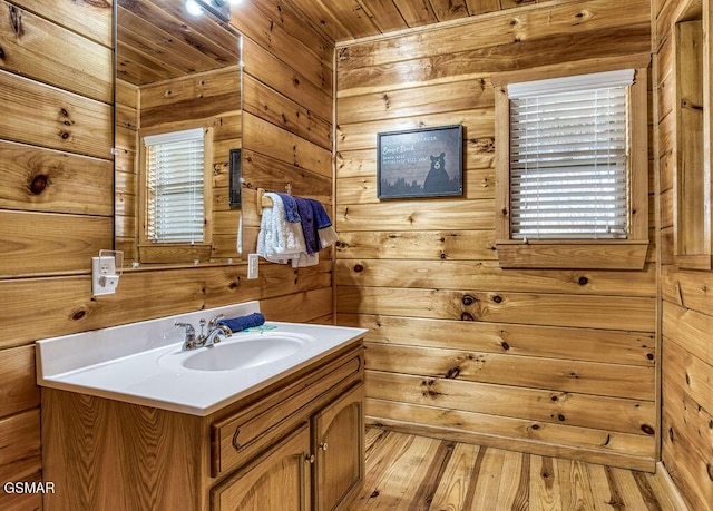 bathroom featuring wood ceiling, wooden walls, vanity, and wood finished floors