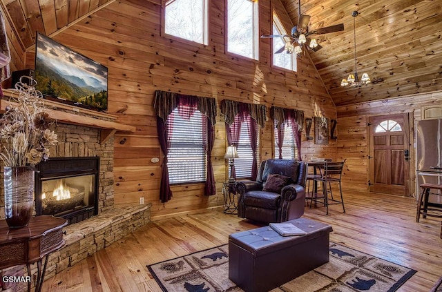 living room with wood-type flooring, wood walls, and ceiling fan