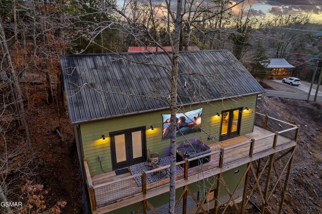1719 Walker Trl, Sevierville, TN 37876 - back of house at dusk with french doors, metal roof, and a wooden deck