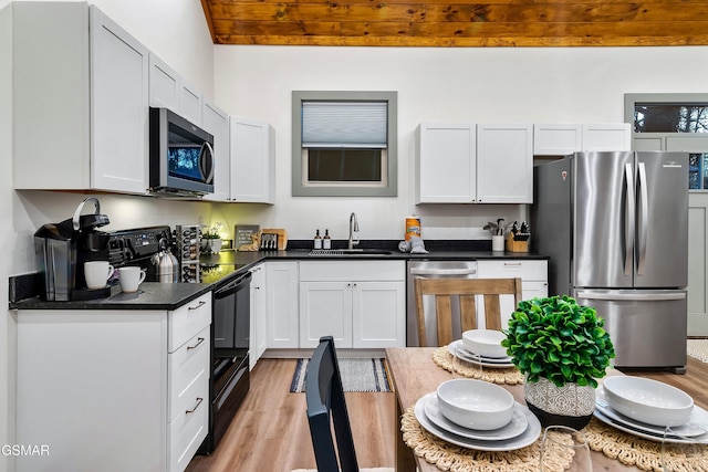 1719 Walker Trl, Sevierville, TN 37876 - kitchen with appliances with stainless steel finishes, a sink, light wood finished floors, dark countertops, and white cabinets