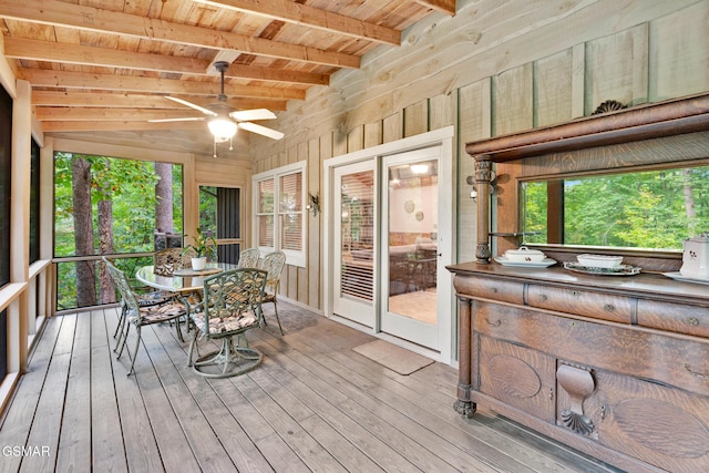 unfurnished sunroom featuring ceiling fan, wooden ceiling, and lofted ceiling with beams