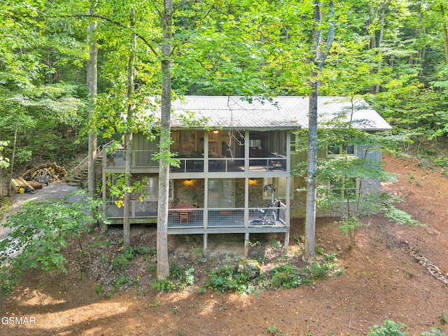 back of property with a deck and a sunroom