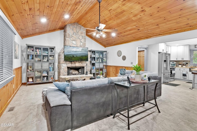 living room with lofted ceiling, a fireplace, wood walls, and wooden ceiling