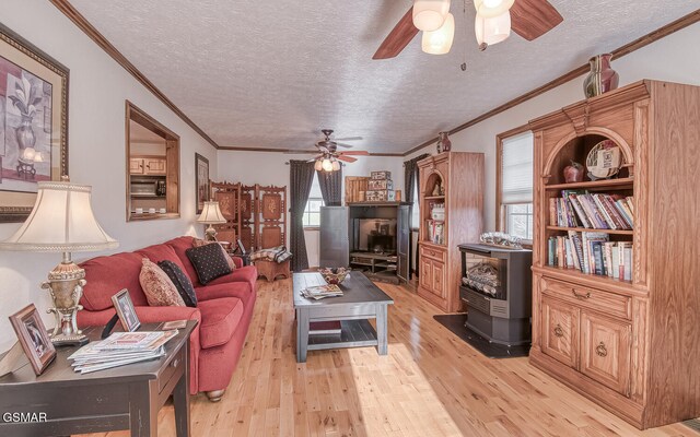 150 Florence Cir, Dandridge, TN 37725 - living room featuring crown molding, a wood stove, a textured ceiling, and light hardwood / wood-style flooring