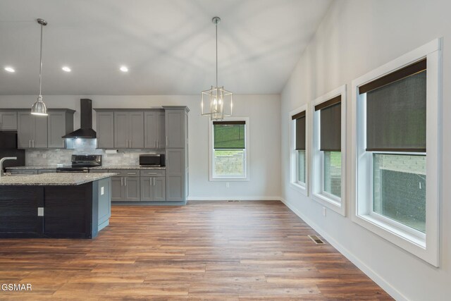 kitchen featuring wall chimney exhaust hood, stainless steel range with electric cooktop, gray cabinets, backsplash, and recessed lighting