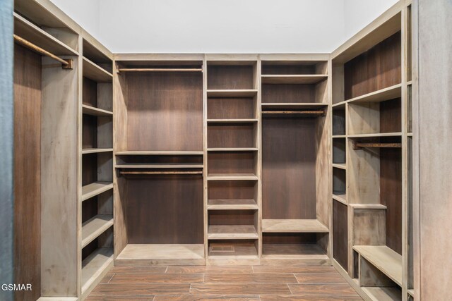 walk in closet with wood finished floors