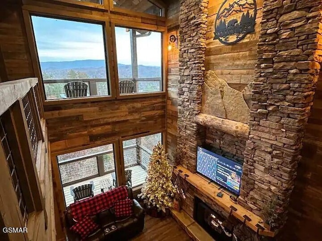 living area with dark wood-style floors, wood walls, and a mountain view