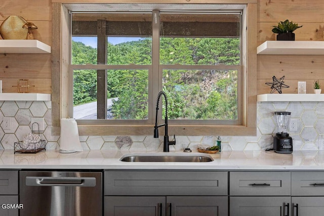 kitchen featuring open shelves, gray cabinets, and stainless steel dishwasher