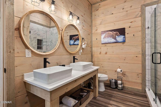 bathroom with a sink, toilet, and wooden walls