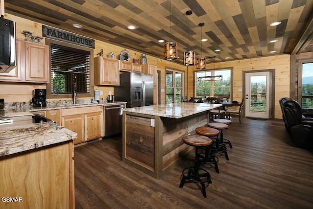 kitchen with appliances with stainless steel finishes, a sink, dark wood-style floors, and light brown cabinetry